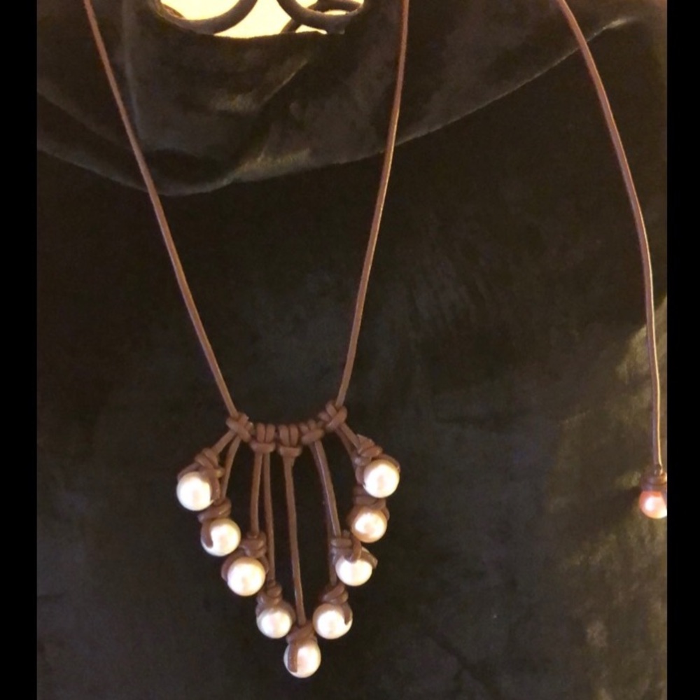 Genuine pearl necklace on leather slide.